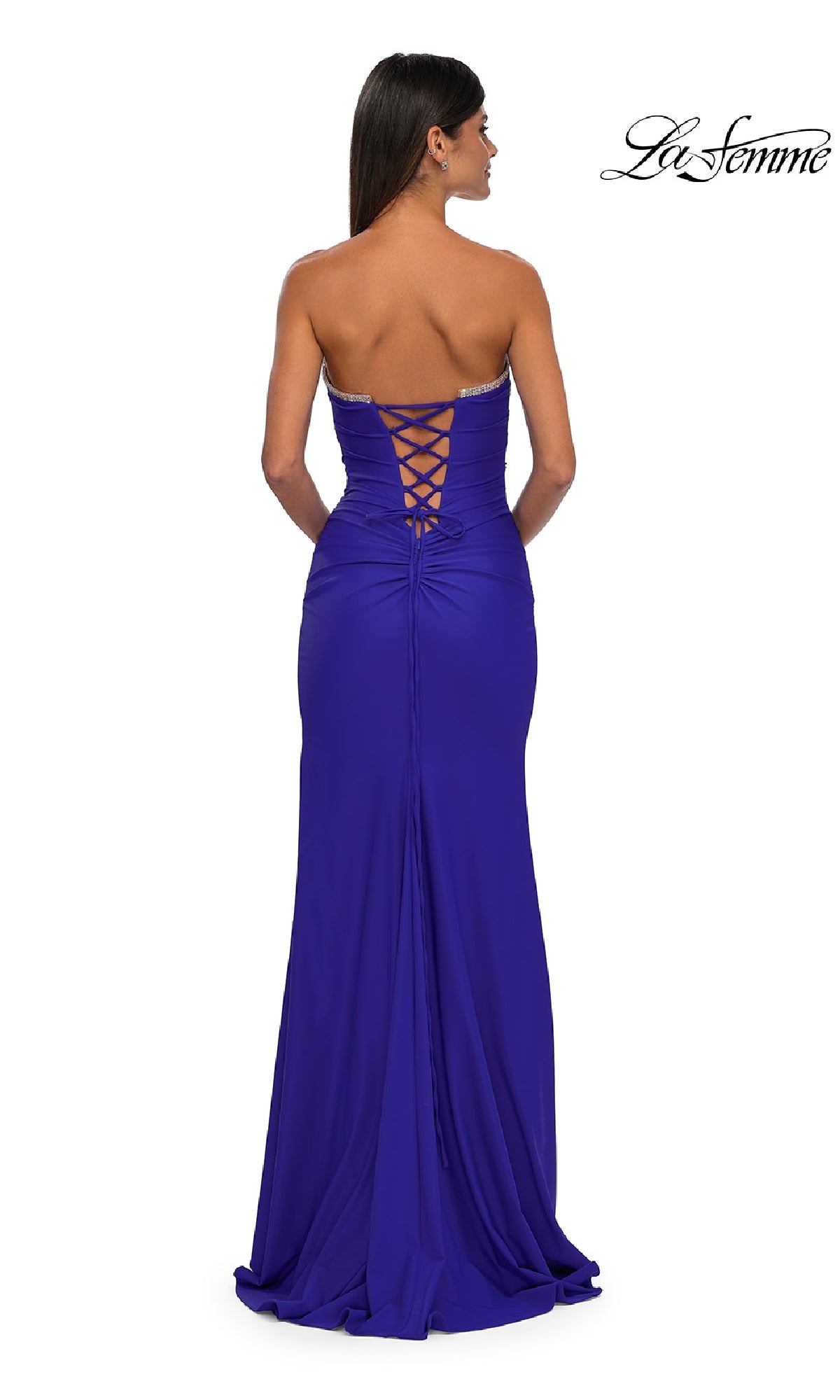 Wearing the La Femme 32931 Lace-Up Strapless Long Prom Dress in royal blue, a woman stands with her back to the camera, highlighting the elegant silhouette and dramatic floor-length lace-up back design.